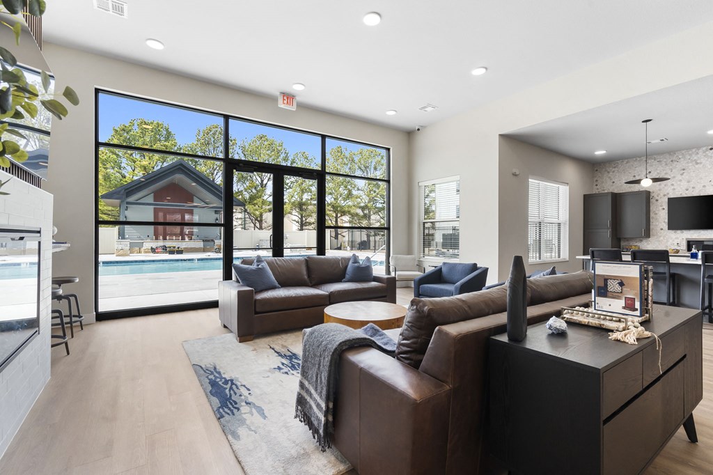 a living room with couches and a tv in front of a pool at The Junction at Rogers, Rogers, 72756
