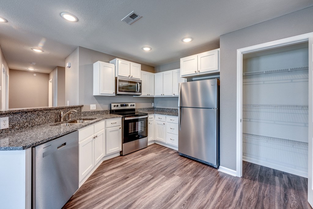 A kitchen with white cabinets and stainless steel appliances.