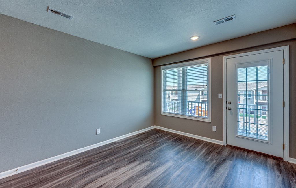 A room with a brown floor and a white door.