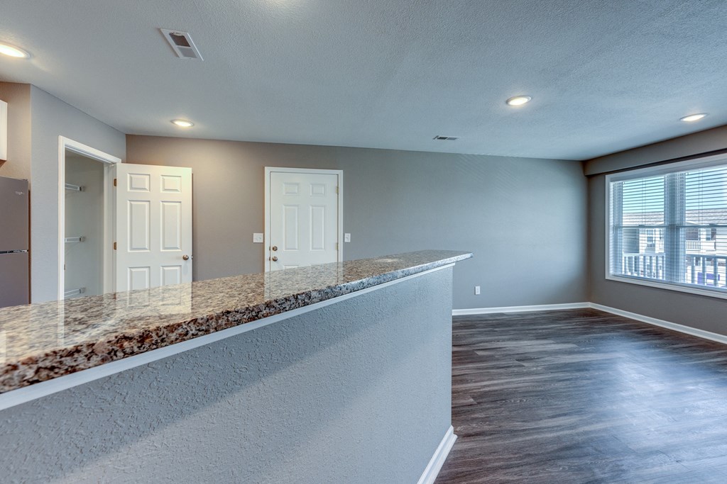 A room with a marble countertop and wooden flooring.