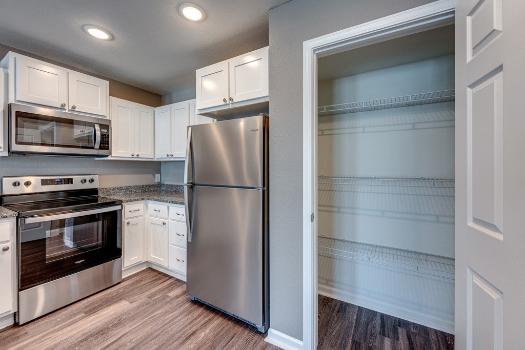 A modern kitchen with a stainless steel refrigerator and oven.
