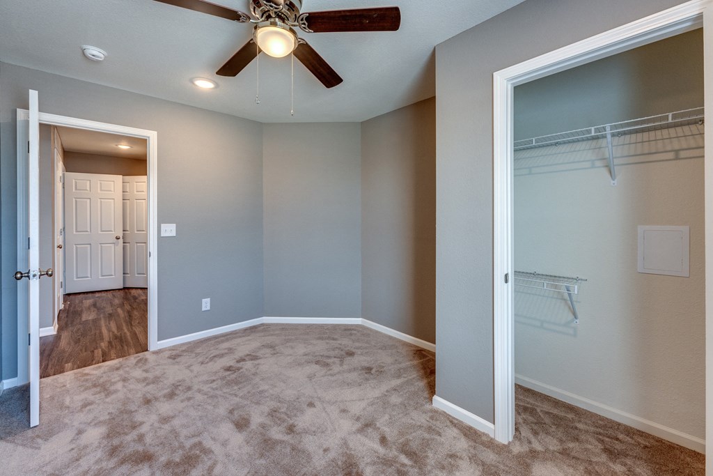 A room with a ceiling fan and a carpeted floor.