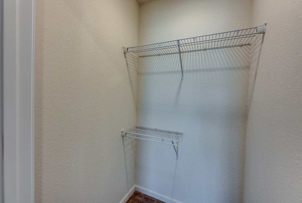 Empty wire shelving in a corner of a room.