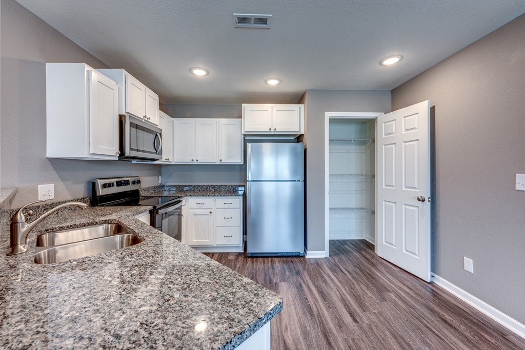 A kitchen with granite countertops and stainless steel appliances.