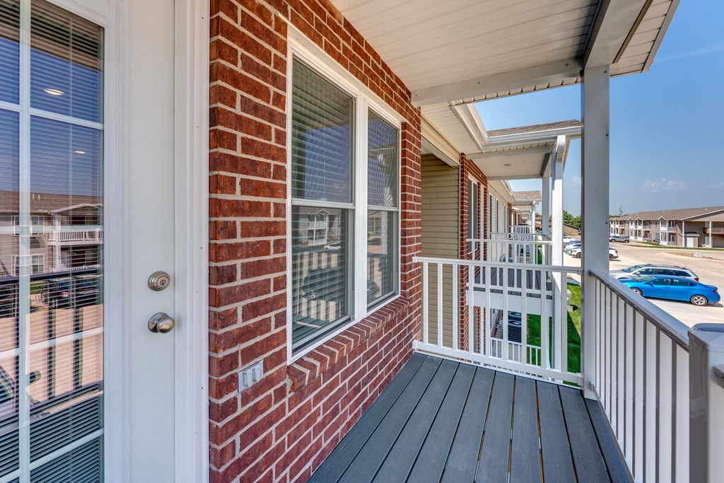 A red brick house with a white door and a white railing.