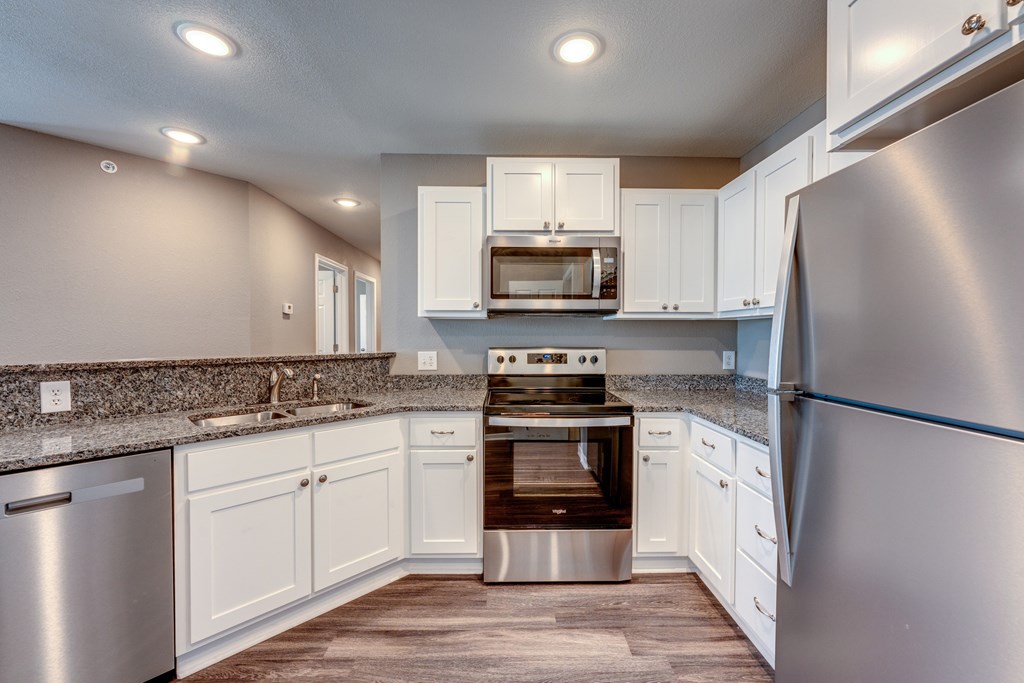 A modern kitchen with stainless steel appliances and white cabinets.