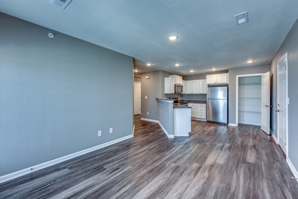 A kitchen with a refrigerator, microwave, and oven is visible in the image.