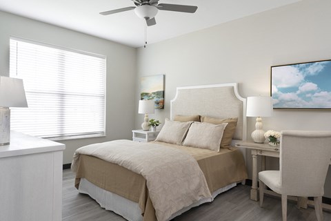 The Oasis at Hartman Lakes main bedroom with light planking flooring, ceiling fan and large window
