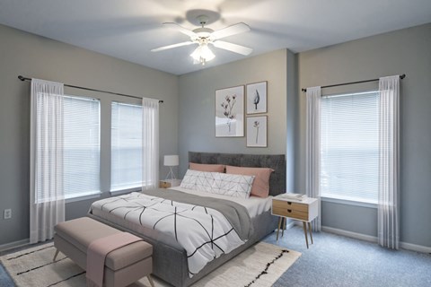 A bedroom with a large bed and a ceiling fan.