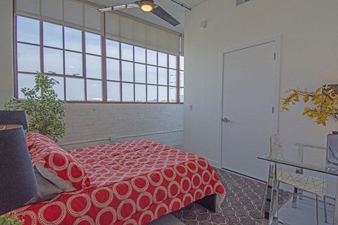 a bedroom with a bed and a large window