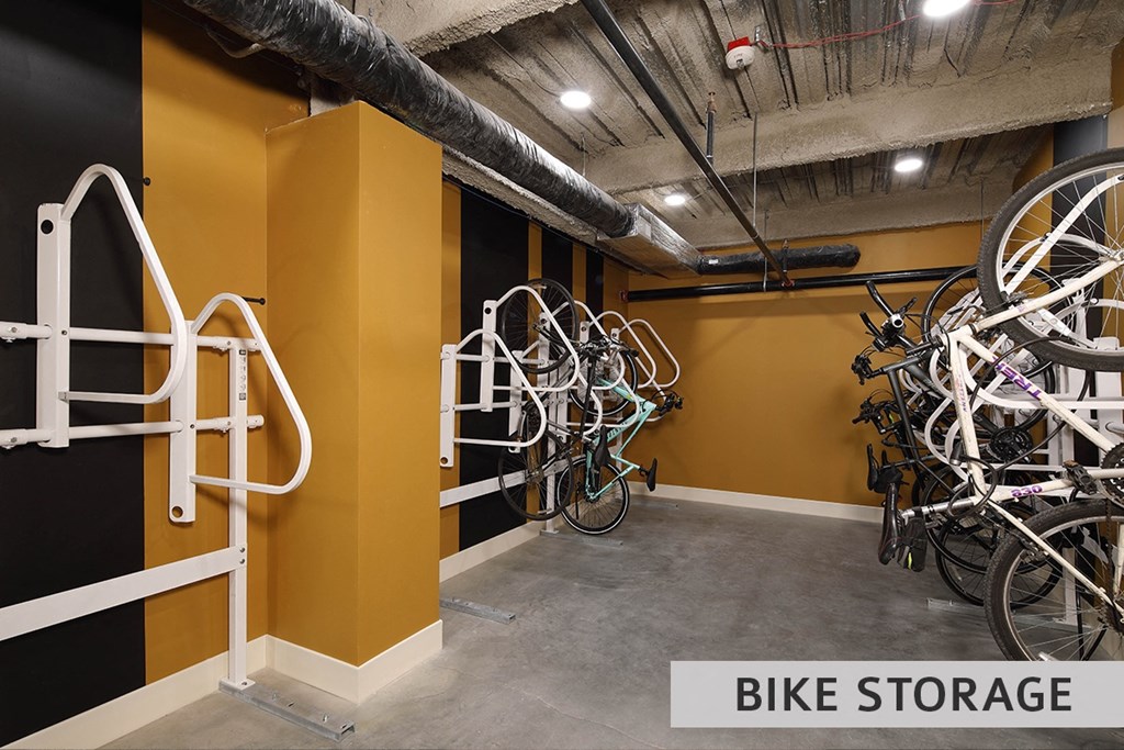 a bike storage area with a yellow wall and white bike racks  at Expo at Forest Park, Missouri