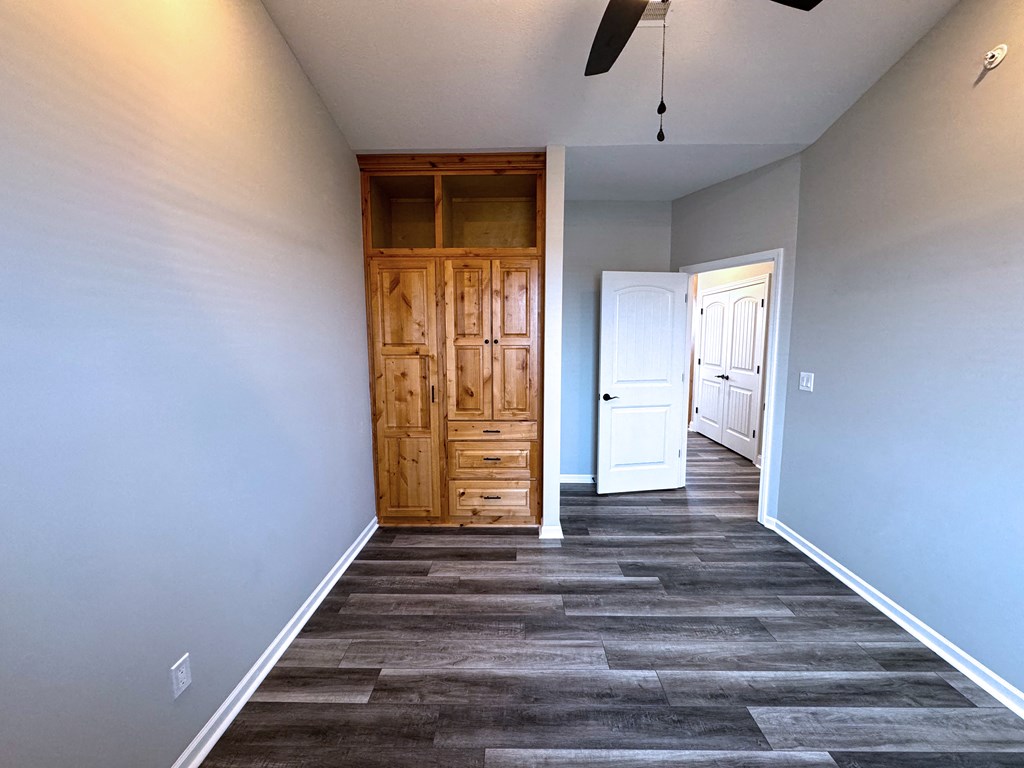 A room with a wooden door and a ceiling fan.