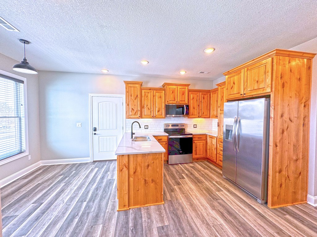 A kitchen with wooden cabinets and a refrigerator.