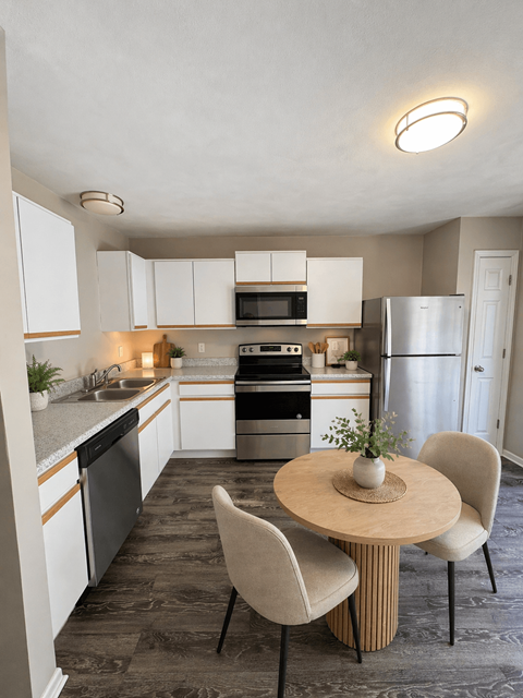 A kitchen with a table and chairs.