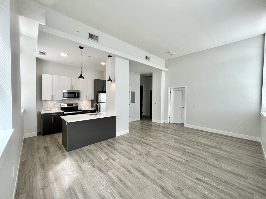 A spacious kitchen with a bar area and a dining table.