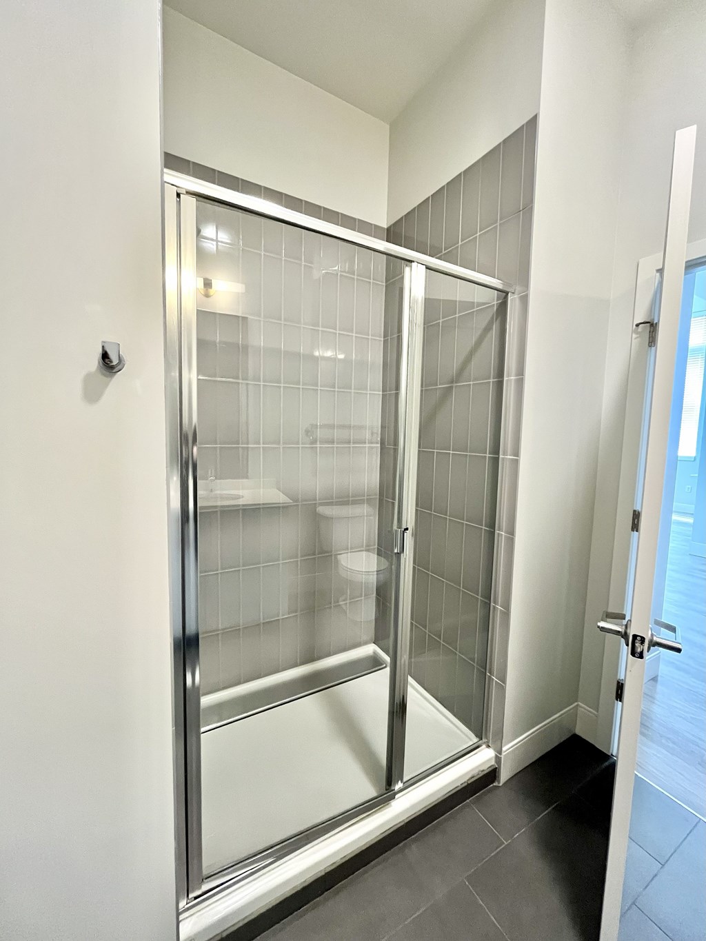 A glass shower stall with a door and a handle.