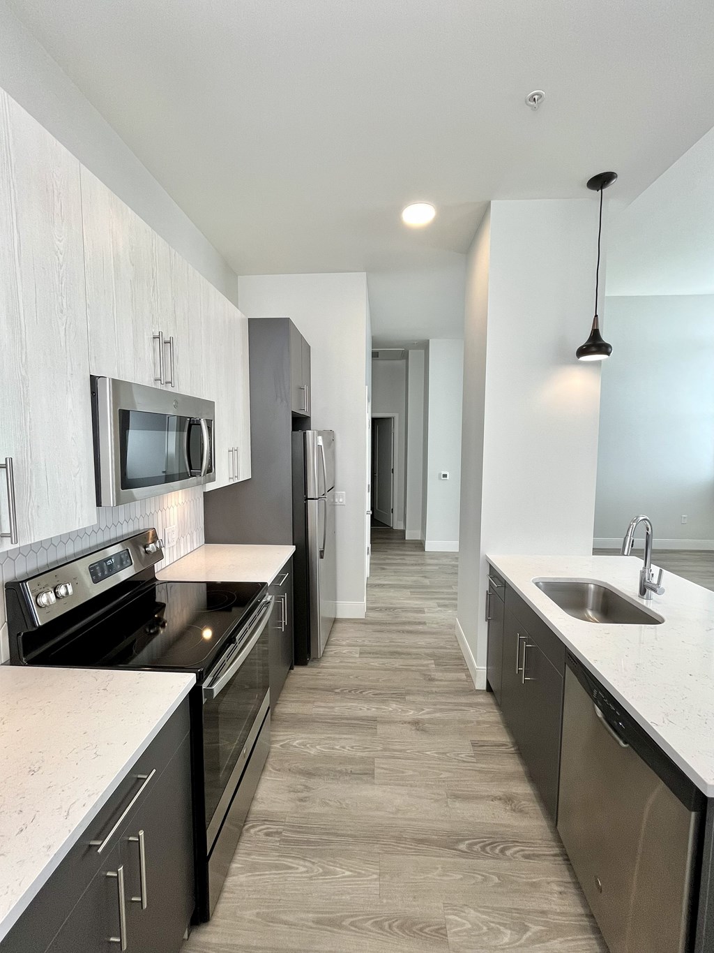 A modern kitchen with dark wood cabinets and stainless steel appliances.