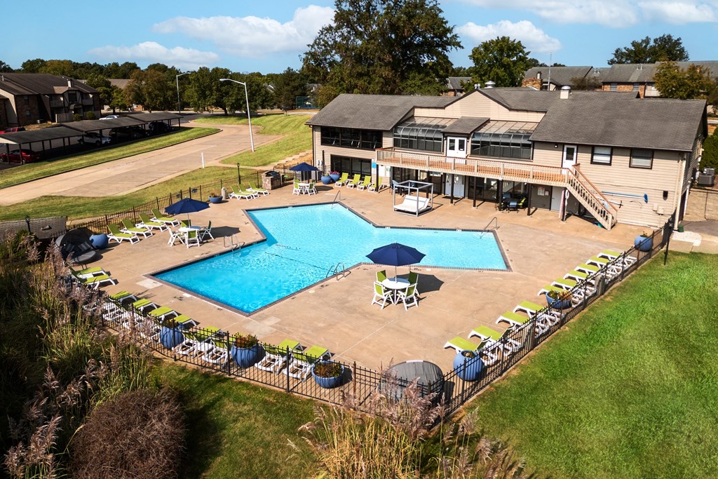 arial view of a pool with a house in the background