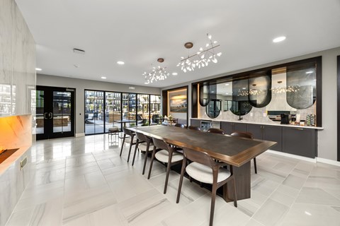 A modern dining room with a wooden table and chairs at The Cunningham Apartments, West Des Moines