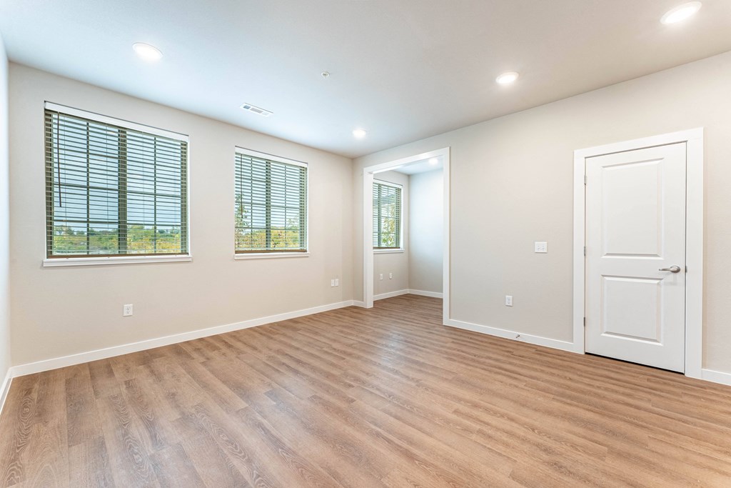 living room with can lighting, large windows and vinyl plank flooring at Pure Lowell, Lowell, AR 72745