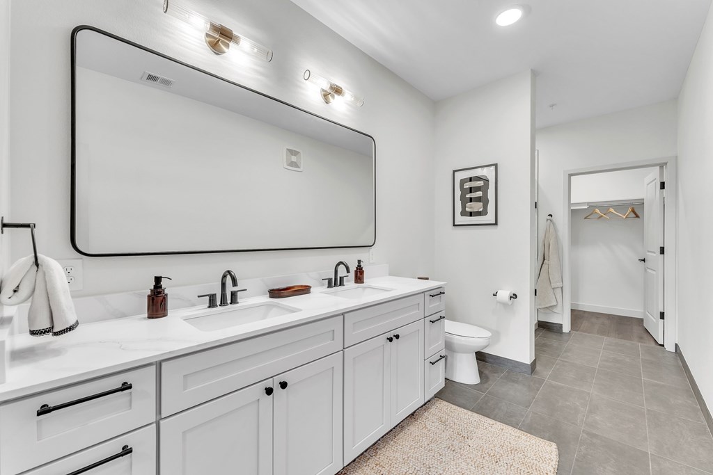 A bathroom with a white sink and a large mirror.