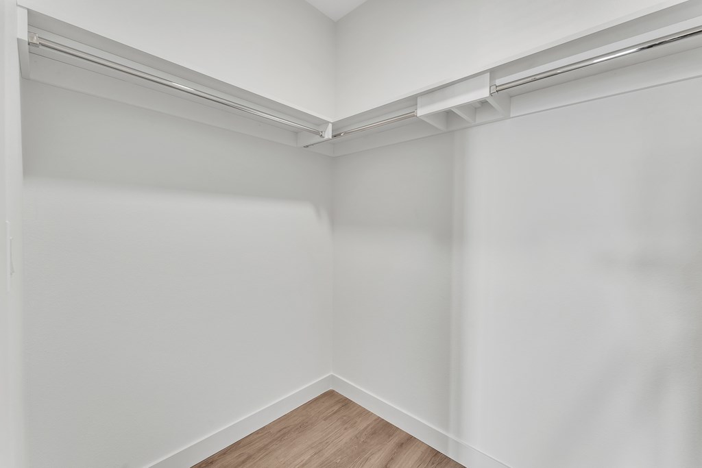 A white wall with a wooden floor and a white ceiling.