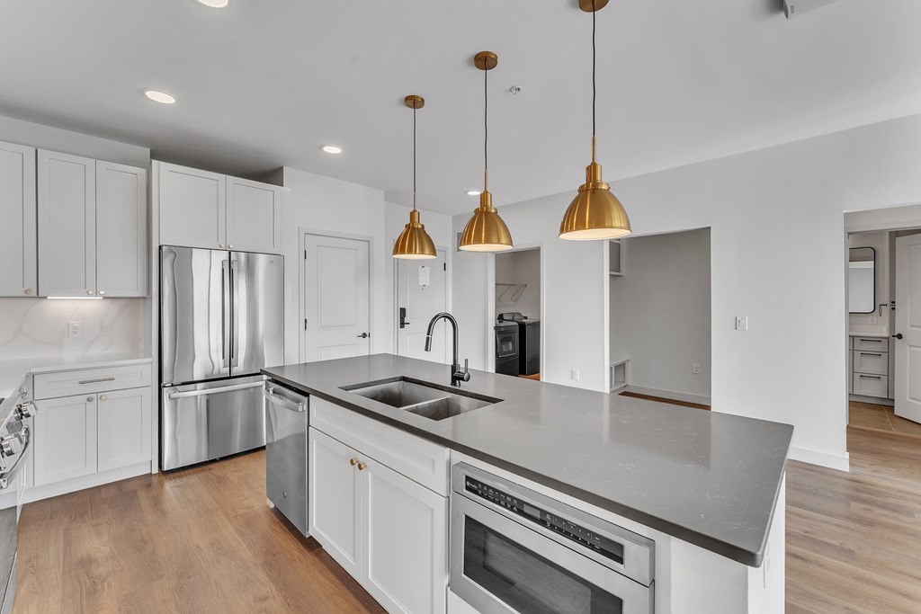 A modern kitchen with a large island and stainless steel appliances.