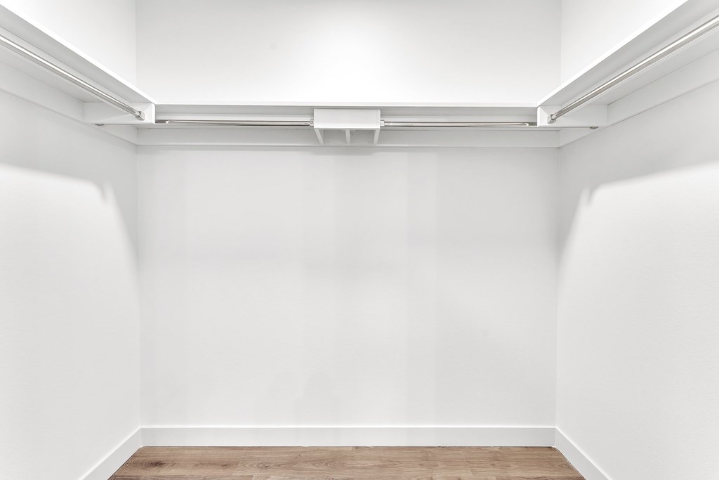 A white wall with a vent on the ceiling.