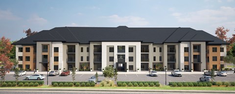 A large, modern building with a black roof and a parking lot in front.