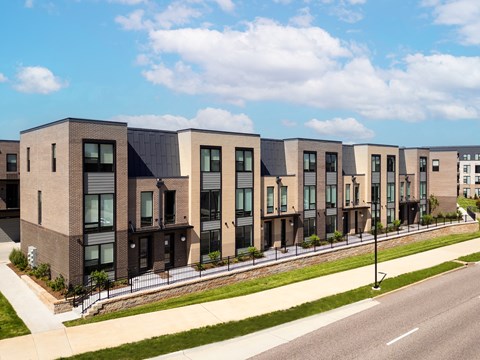 a row of townhouses on the side of a street at The Flats & Terraces at Wildhorse Village, Missouri, 63005
