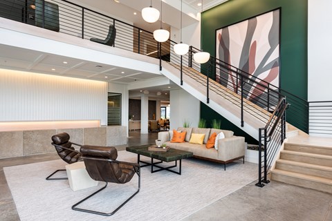 a living room with a staircase and a couch and a table at The Flats & Terraces at Wildhorse Village, Chesterfield