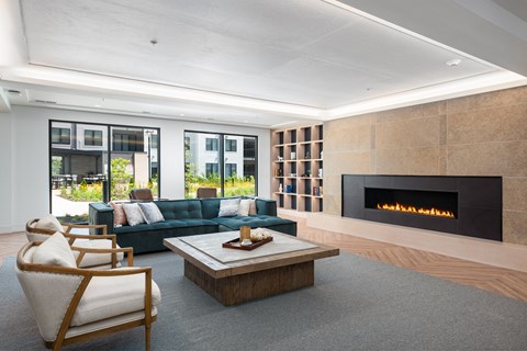 a living room with a blue couch and a fireplace at The Flats & Terraces at Wildhorse Village, Chesterfield, 63005