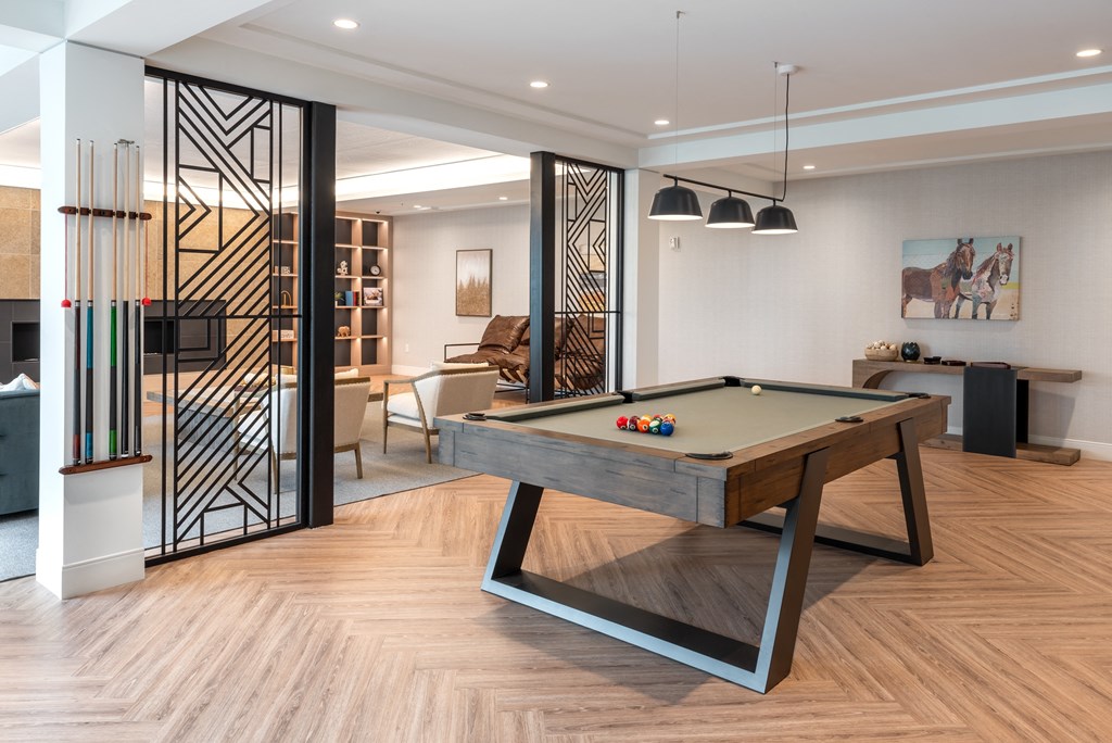 a billiards table in a living room with a glass door