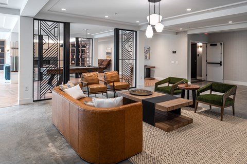 a living room with a couch and chairs and a staircase at The Flats & Terraces at Wildhorse Village, Missouri
