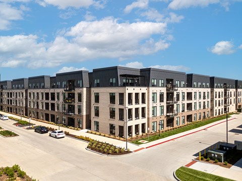 an aerial view of a row of apartment buildings on a city street at The Flats & Terraces at Wildhorse Village, Chesterfield, 63005