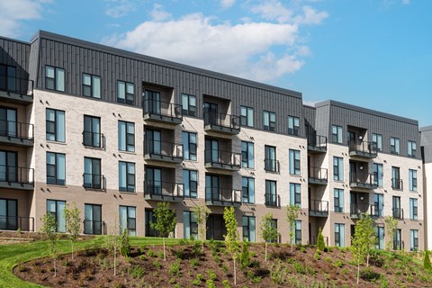 the exterior of a large apartment building with balconies at The Flats & Terraces at Wildhorse Village, Missouri