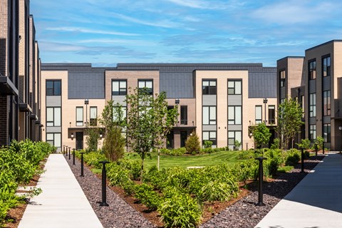 a row of apartment buildings with a sidewalk in front of them at The Flats & Terraces at Wildhorse Village, Missouri, 63005