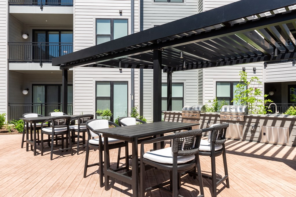 a patio with tables and chairs under an awning