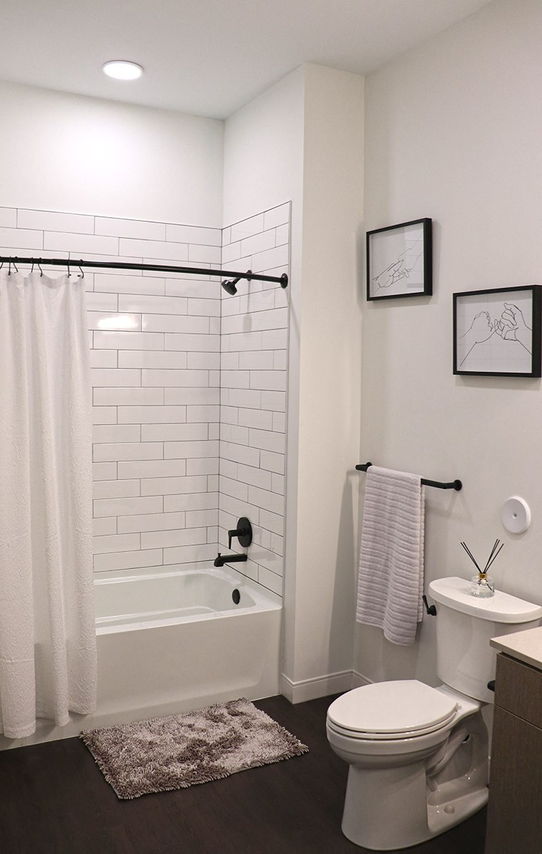 a white bathroom with a tub and a toilet and a sink