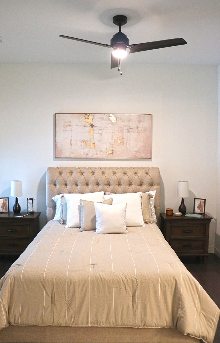 a bedroom with a bed and a ceiling fan