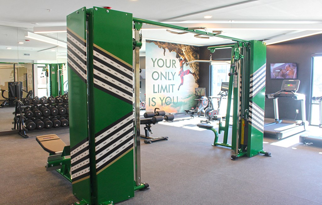 a gym with green equipment and a sign that says your only limit is you