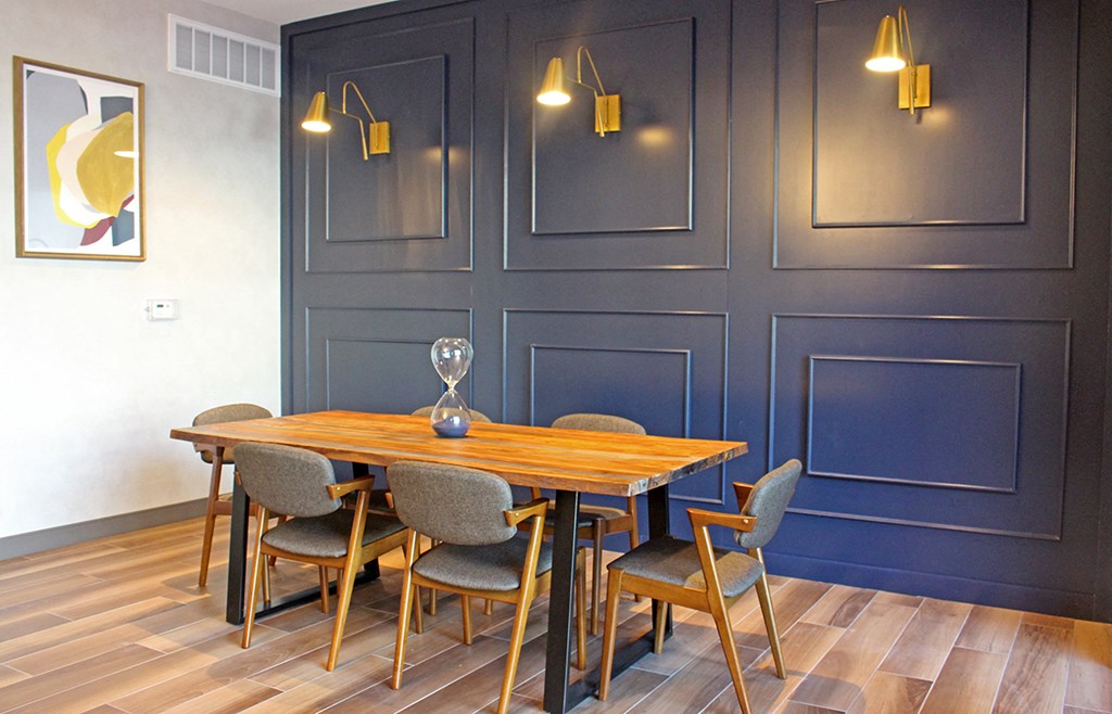 a dining room with blue walls and a wooden table and chairs