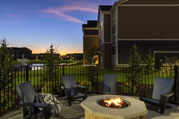 exterior photo of black chairs surrounding round gas firepit - Photo Gallery 15