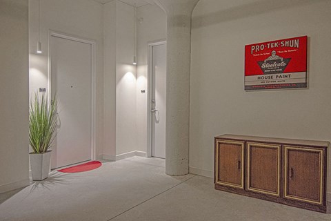 a lobby with a red sign on the wall and a plant