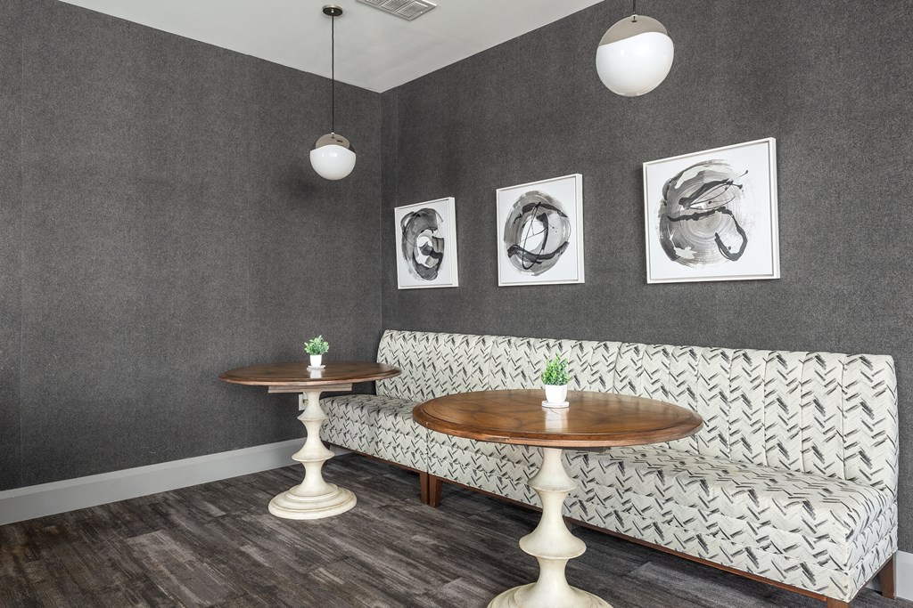 two tables and a couch in a room with paintings on the wall at Hibernia Apartments, St Louis, MO, 63139