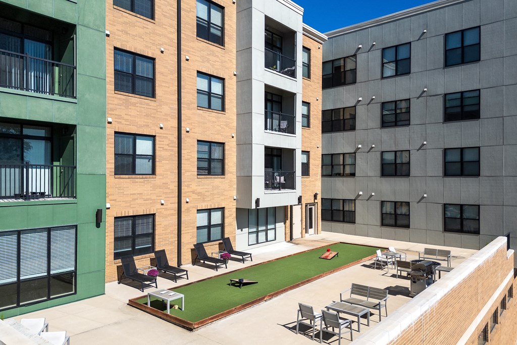 Hibernia resident amenity deck with gaming turf, conversational seating and grilling station at Hibernia Apartments, St Louis, MO, 63139
