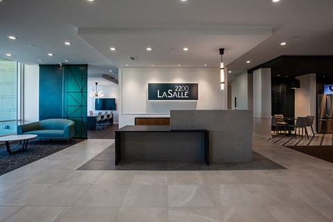 a modern hotel lobby with a large reception desk and blue chairs  at 2200 LaSalle, St Louis, 63104