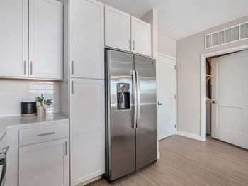 a kitchen with white cabinets and a stainless steel refrigerator - Photo Gallery 29