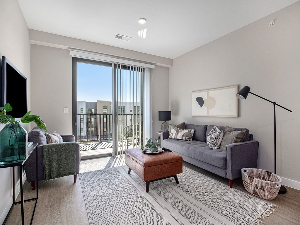 a living room with a grey couch and a brown coffee table  at Signature at West Pryor, Missouri, 64081