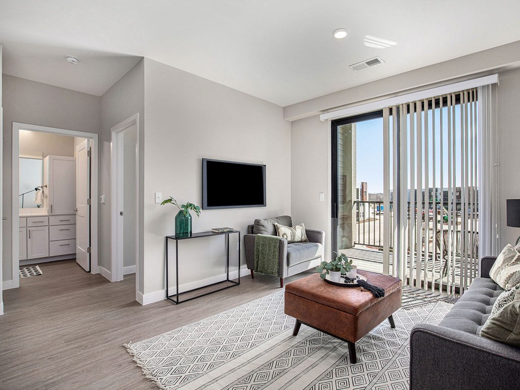 a living room with a couch and a chair  at Signature at West Pryor, Lee's Summit, MO